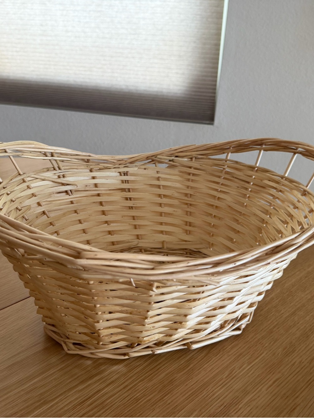 Natural woven wicker basket with a curved oval shape
